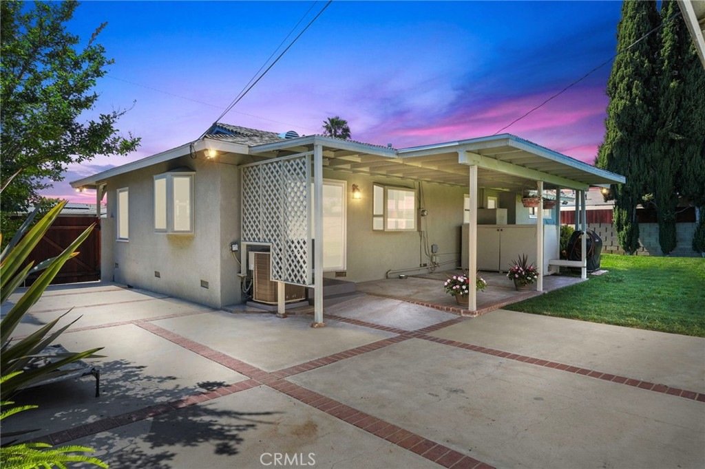 Single-story home on Kathy Ln, Garden Grove, CA, featuring a covered patio, lattice wall, and sunset sky.