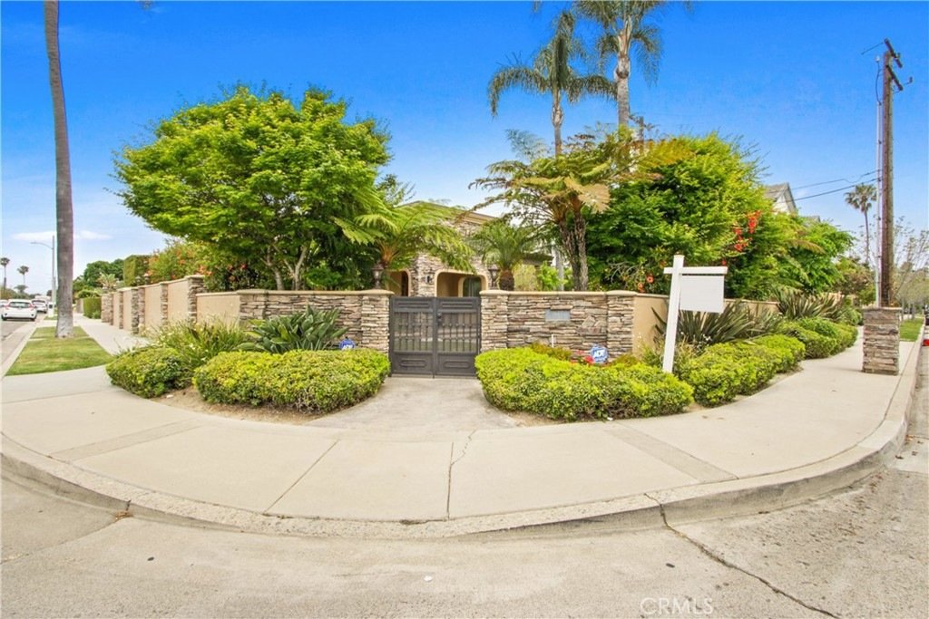Modern California home on Tustin Ave in Costa Mesa featuring a gray garage door, wood accents, and a front porch.