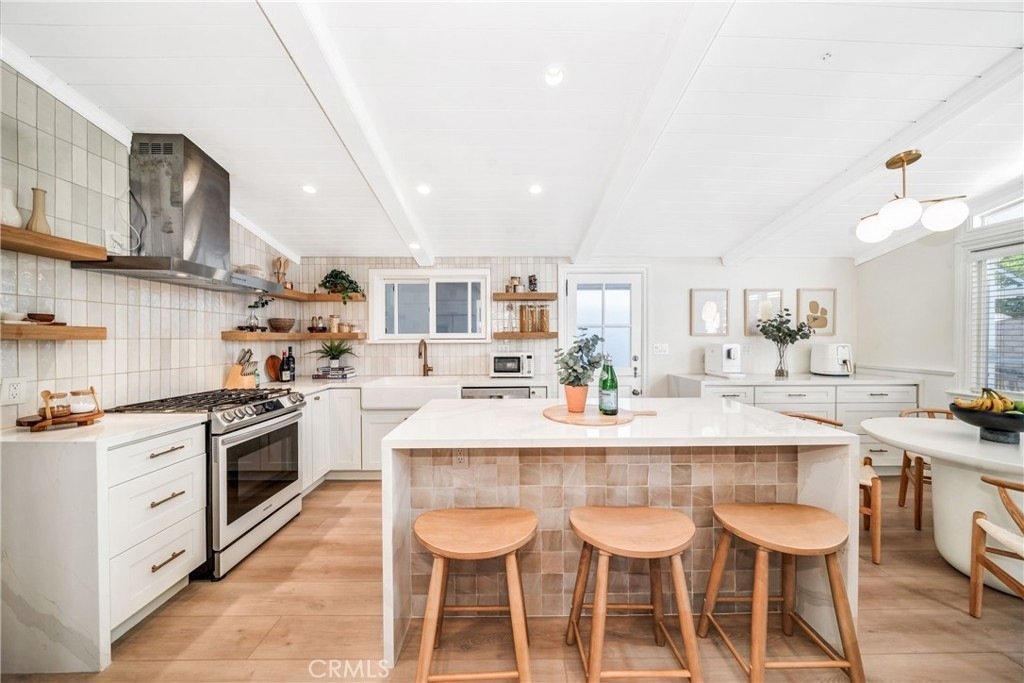 Living room on Hanover Dr, Costa Mesa, CA, with a wood ceiling, gray couch, TV, fireplace, and big windows.