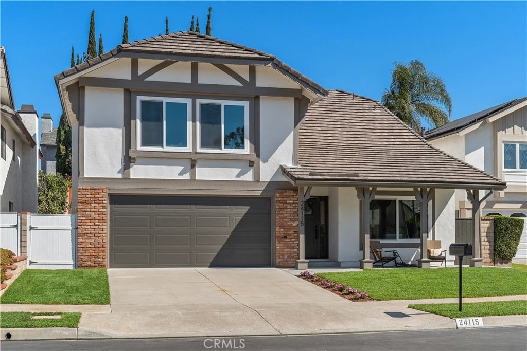 Modern California home on Cindy Ln in Lake Forest featuring a gray garage, wood and brick accents, and a front porch.