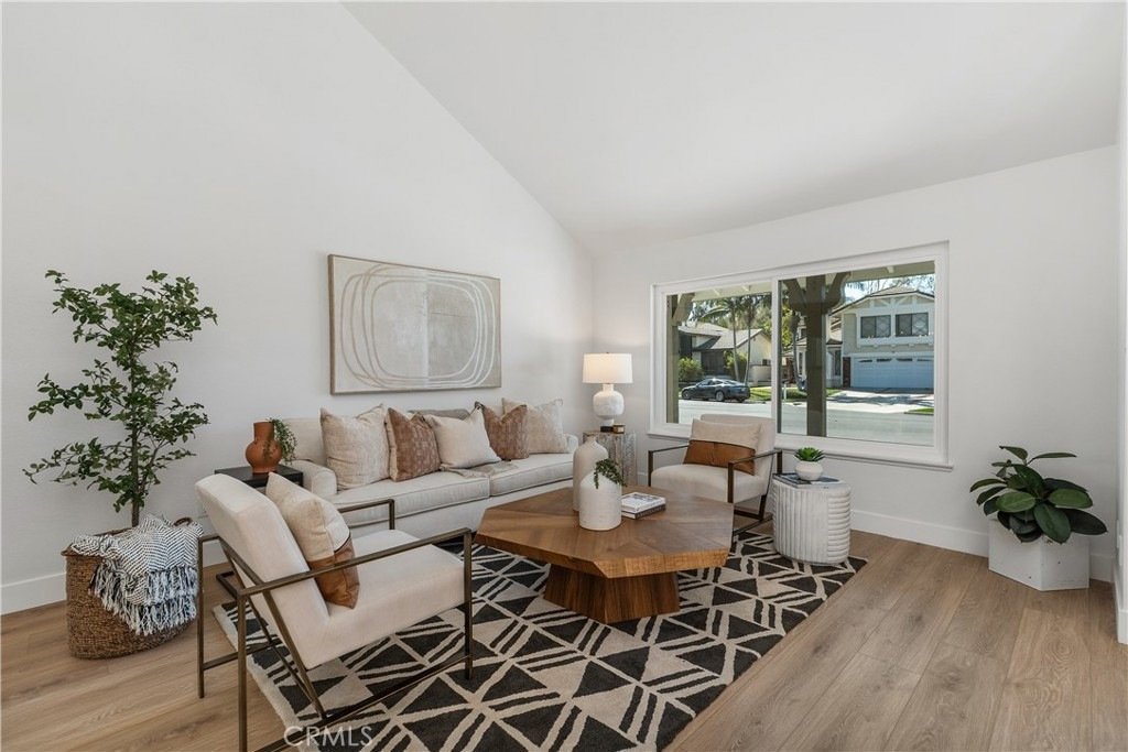 Bright California living room on Cindy Ln in Lake Forest with a white sofa, wooden coffee table, and street view.